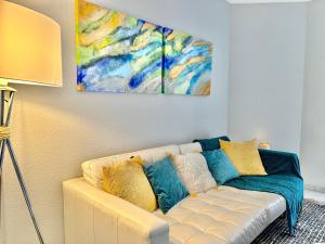 a living room with a couch and a painting on the wall at City Center Marbella Apartment - EaW Homes in Marbella