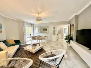 a living room with a couch and a tv at City Center Marbella Apartment - EaW Homes in Marbella
