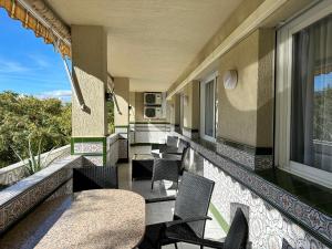 a balcony with chairs and tables on a building at City Center Marbella Apartment - EaW Homes in Marbella