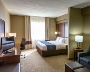 a hotel room with a bed and a television at Comfort Suites Idabel in Idabel