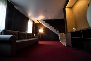 ルツカイにあるSribni Leleky Hotel & Spaのソファと階段のあるリビングルーム