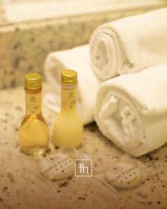 dos botellas de aceites esenciales sentadas junto a las toallas en Hotel Franco en Dionísio Cerqueira