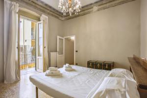 une chambre avec un lit et un lustre dans l'établissement Myosotis - Sweet Dreams in Florence, à Florence