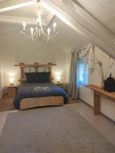 - une chambre avec un lit et un lustre dans l'établissement Les Muzards, à Châtel-Montagne