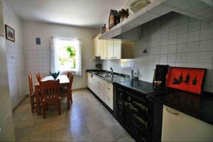 PRIVATE COUNTRY HOUSE 2000 MTRS LANZADA BEACH في بونتيفيدرا: مطبخ مع طاولة وغرفة طعام