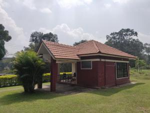 a small red brick house with a porch at Dubare Inn in Madikeri