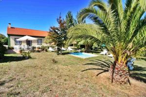 a palm tree in front of a house at PRIVATE COUNTRY HOUSE 2000 MTRS LANZADA BEACH in Pontevedra