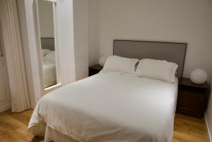 una camera con letto bianco e specchio di Exclusive Apartment in Historic Center a Madrid