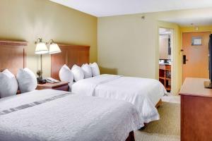 a hotel room with two beds with white sheets at Wingate by Wyndham Cranberry in Cranberry Township
