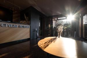 a table with a vase of flowers on top of it at Sribni Leleky Hotel & Spa in Luts'k