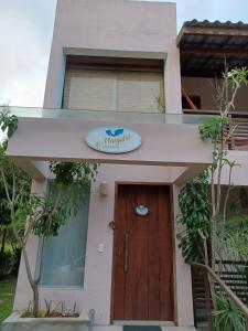 a house with a sign above the door at Manjuba Pousada - Taipu de Fora in Barra Grande