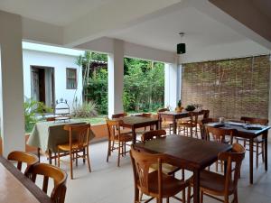 a restaurant with tables and chairs in a room at Manjuba Pousada - Taipu de Fora in Taipu