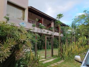 a house with a balcony with plants on it at Manjuba Pousada - Taipu de Fora in Barra Grande