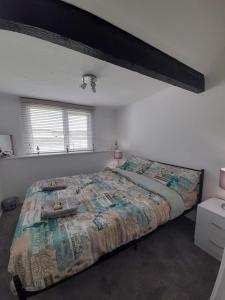a bedroom with a large bed and a window at The Lobster Pot Cottage Church Bay in Llanrhyddlad