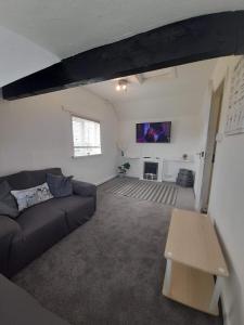 a living room with a couch and a table at The Lobster Pot Cottage Church Bay in Llanrhyddlad