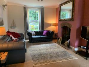 a living room with a couch and a fireplace at Smart & Comfortable 3-bedroom Victorian house in Stalham