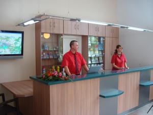 un hombre y una mujer parados detrás de un mostrador en Landguthotel Hotel-Pension Sperlingshof, en Dallgow