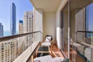 uma varanda com cadeiras e vista para a cidade em Luxury JBR Shams - Sea or Marina View - Free 5 star Beach Resorts Access! em Dubai