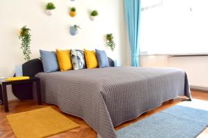 1 dormitorio con 1 cama con almohadas amarillas y azules en Old Town Konviktská - Bohemian Residence en Praga
