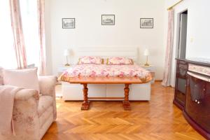 プラハにあるOld Town Konviktská - Bohemian Residenceのベッドルーム(ベッド1台、ソファ、テレビ付)