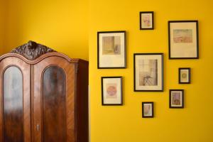 pared amarilla con armario de madera y cuadros enmarcados en Old Town Konviktská - Bohemian Residence en Praga