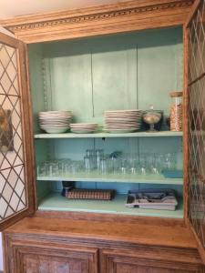 a cabinet filled with plates and bowls and dishes at Les Muzards in Châtel-Montagne