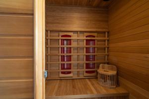 a sauna with wood paneling and a basket in a room at Cozy terraced house with infra sauna and parking in Jesenice