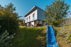 Jesenice的住宿－Cozy terraced house with infra sauna and parking，前面有蓝色滑梯的房子