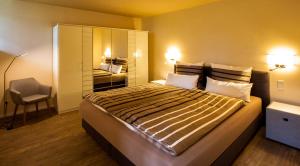 a bedroom with a large bed and a chair at Parkresidenz Lychen, Ferienwohnung 1 in Lychen