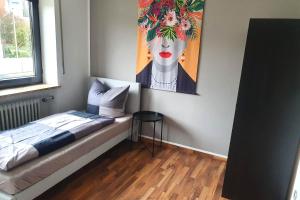 ein Schlafzimmer mit einem Bett und einem Wandgemälde in der Unterkunft Work & stay apartment with balcony near Ingolstadt in Großmehring