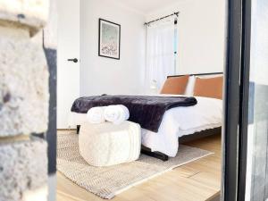 a bedroom with a bed and a table with towels on it at The Shoreline - Absolute Beachfront 2BR Batehaven in Batehaven