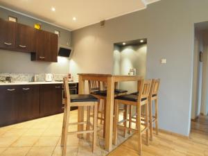 cocina con mesa de madera y sillas en Gama K2124 Grand-Tourist Apartments, en Gdansk
