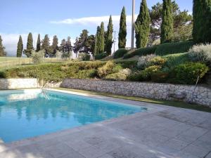 una piscina en un jardín con una pared de piedra en La Poderina, en Cetona