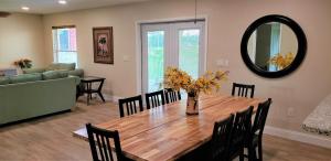 comedor con mesa con sillas y espejo en Little Ridge Ranch-East House Quiet Country Getaway-Pet Friendly!, en Williston