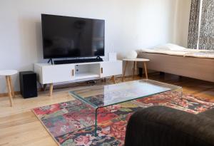 een woonkamer met een tv en een glazen salontafel bij 2ndhomes Luxury Kamppi Center Apartment with Sauna and Terrace in Helsinki