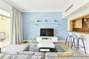 een woonkamer met een bank en een tafel bij Shoreline · Beachfront Luxury Palm Jumeirah · Free 5* Beach Resorts Access in Dubai