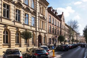 una fila di auto parcheggiate in una strada accanto a un edificio di City of the Kings-Old Town Pastel Apartment a Cracovia