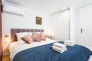 una camera da letto con un grande letto con asciugamani di City of the Kings-Old Town Pastel Apartment a Cracovia