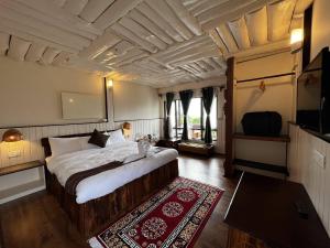 a bedroom with a large bed and a television at The Nettle and Fern Farmstay in Pelling