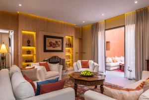 a living room with white couches and a table at Berbère Palace in Ouarzazate