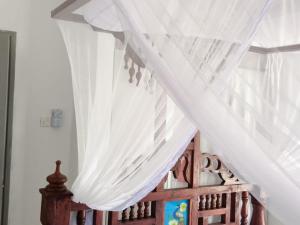 ein weißer Vorhang über einer Holztreppe in der Unterkunft PahaliMzuri Kijani - 1 Bedroom Beach Apartment with Swimming Pool in Malindi + 38 Fotos
