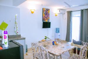 a dining room with a table and chairs in a room at PahaliMzuri Kijani - 1 Bedroom Beach Apartment with Swimming Pool in Malindi
