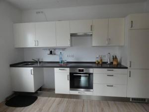 a kitchen with white cabinets and a black counter top at Mainroom Kitzingen in Kitzingen