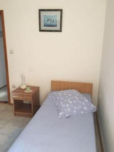 a small bedroom with a bed and a night stand at Apartment in Tribunj with terrace, air conditioning, WiFi 5038-4 in Tribunj