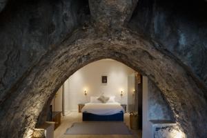 a bedroom with a bed in a stone wall at Tel-Aviv LALA Boutique Hotel in Tel Aviv