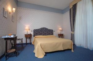 a bedroom with a bed and two tables and two lamps at Hotel Nuovo Rebecchino in Naples