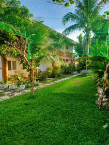 a green yard with palm trees and a building at Hotel Renate in Panglao