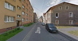 a car parked on a street next to buildings at Apartament Alpejski Mały in Lądek-Zdrój