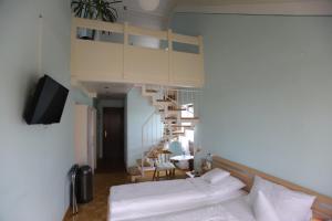 a living room with a white couch and a spiral staircase at Gasthof - Pension Krämerhof in Thanstein +23 photos