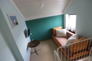 ThansteinにあるGasthof - Pension Krämerhofのソファとベビーベッド付きの小さな部屋です。